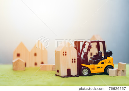 wooden small home model with forklift car for moving house or home building renovation for good community concept 76626367