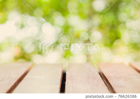 Wood table top blur natural green morning garden background for montage products display advertising layout Wood table top blur natural green morning garden background for montage products display advertising layout 76626386