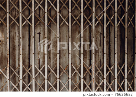 Old grunge rusty shutter folding door for shop closed or business down concept, texture pattern or steel gate. 76626682