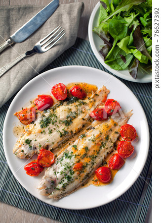 Sole with cherry tomatoes on a plate. High quality photo. 76627392