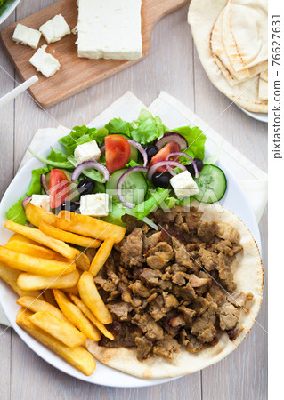 Greek Gyros with Fries and Salad on a Plate. 76627631