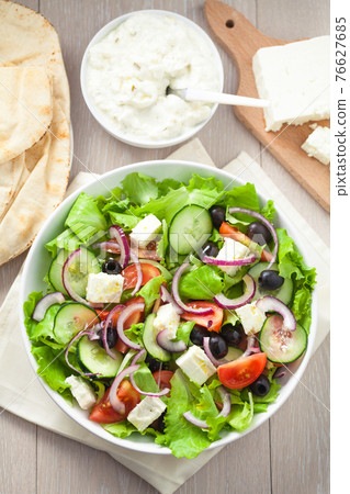 Greek salad with tomatoes, feta, olives and cucumbers. 76627685