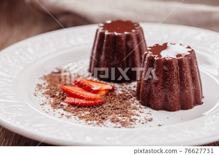 Chocolate pudding with fresh strawberries on a plate. Chocolate pudding with fresh strawberries on a plate. 76627731