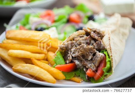 Greek Gyros with Fries and Salad on a Plate. 76627737