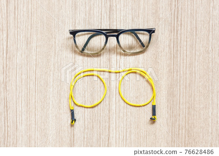 Clear eyeglasses, Glasses transparent dark blue frame with yellow eyeglasses strap on a wooden background 76628486