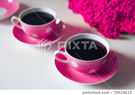Two pink coffee cups on white background, coffee break and caffeine addiction concept. yellow flowers on the table Two pink coffee cups on white background, coffee break and caffeine addiction concept. yellow flowers on the table 76628618