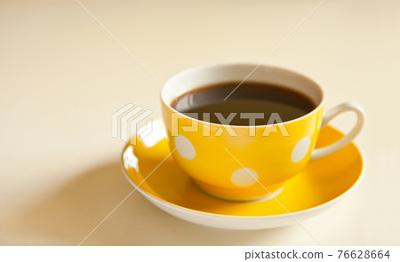 cup of black tea on yellow plate. yellow cup with dots. retro style. vintage mug 76628664