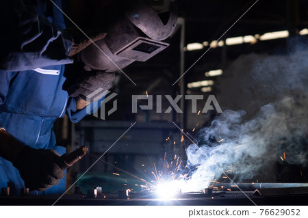 Skillful metal worker working with arc welding machine in factory Skillful metal worker working with arc welding machine in factory 76629052