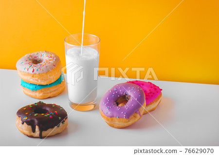 Sweet donuts with a glass of pouring plant milk Sweet donuts with a glass of pouring plant milk 76629070