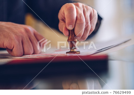 Notary public stamping the agreement or other document. Notary public stamping the agreement or other document. 76629499