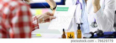 Doctor giving patient prescription for drug in clinic 76629779