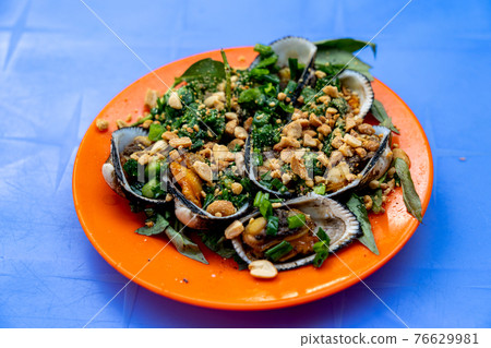 Grilled ark clam served with peanuts, scallion and Vietnamese cilantro Grilled ark clam served with peanuts, scallion and Vietnamese cilantro 76629981