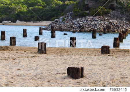Rusty Old Remnant Bridge Base Struts Over Riverbank 76632445