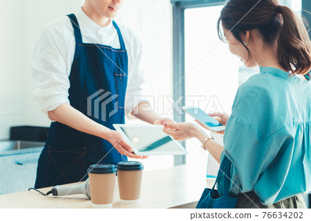 一位女士在收銀台結賬時準備用智能手機付款 一位女士在收銀台結賬時準備用智能手機付款 76634202