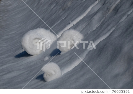 Three snowballs roll on a snowy slope Three snowballs roll on a snowy slope 76635591