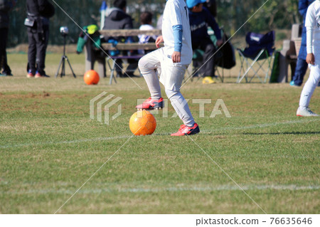A boy kicking a soccer ball in a soccer match A boy kicking a soccer ball in a soccer match 76635646