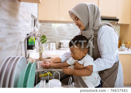 muslim mother wash her son hand in the kitchen sink muslim mother wash her son hand in the kitchen sink 76637481