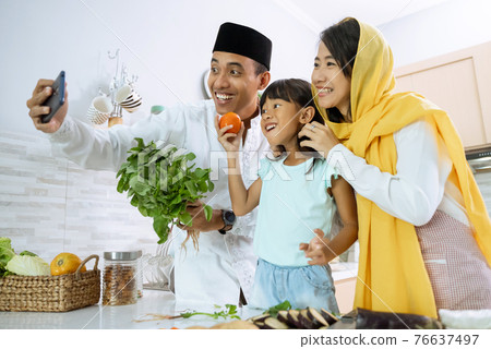 muslim asian family take selfie during iftar dinner preparation 76637497