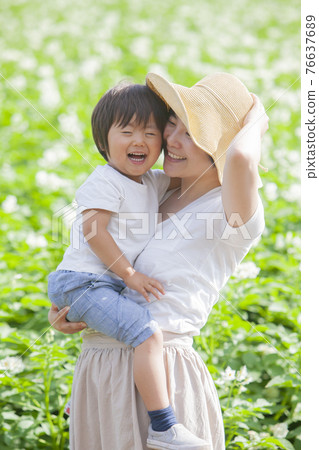 Parents and children playing in a potato field 76637689