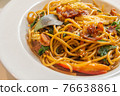 Spicy spaghetti with bacon and basil in the white dish. 76638861