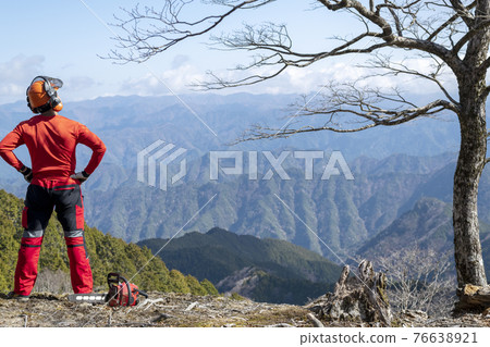 一名男性林業工人站起來看著要維護的山脈 一名男性林業工人站起來看著要維護的山脈 76638921