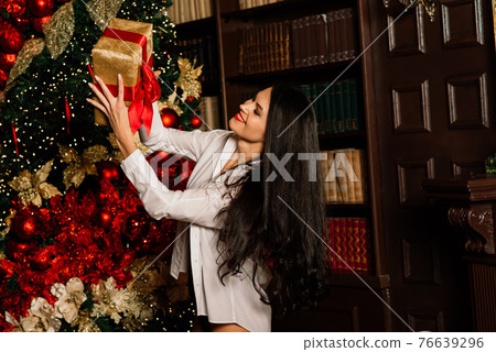 Beautiful young woman in sexual black lingerie posing in Christmas decorations. Beautiful young woman in sexual black lingerie posing in Christmas decorations. 76639296