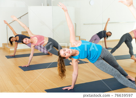 Girl standing in balancing pose Vasisthasana during yoga training 76639597
