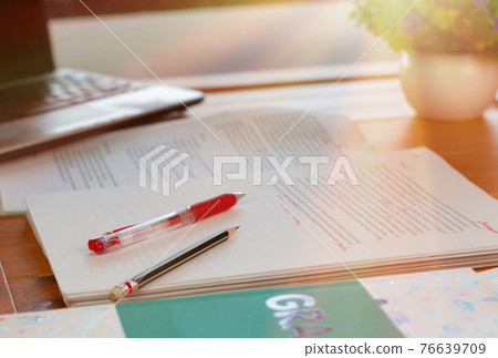 red pen on blurred paperwork and books 76639709