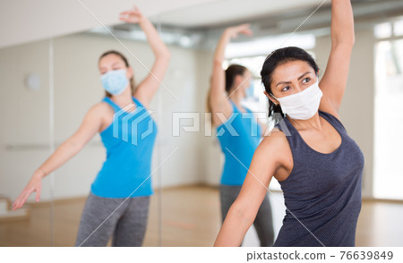 Hispanic woman in protective mask learning dance moves Hispanic woman in protective mask learning dance moves 76639849