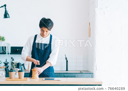 研磨咖啡豆的男性咖啡館工作人員 76640289