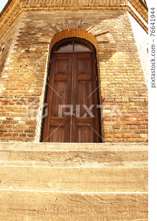 Old wooden door in yellow brick water tower wall downstairs view Old wooden door in yellow brick water tower wall downstairs view 76641944