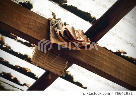 Old weathered brown newspaper hanging on wooden beam Old weathered brown newspaper hanging on wooden beam 76641981