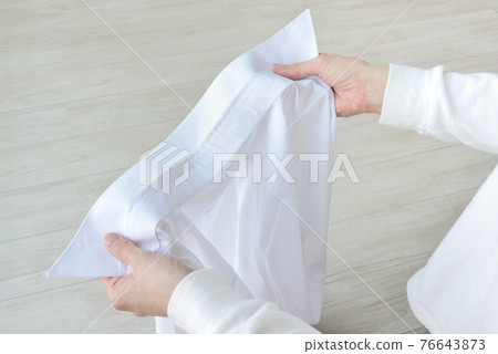 檢查襯衫領子是否有污垢的人的手 76643873