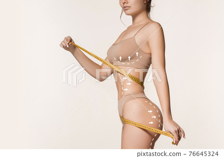 Beautiful slim tanned wonan in underwear isolated over white background. 76645324