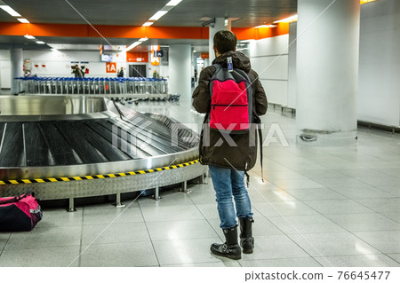 Tourist going to take his baggage 76645477