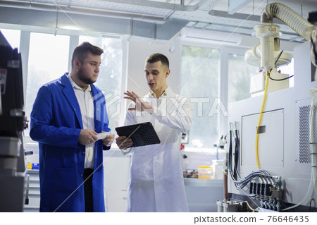 Engineer and technician discussing production process at factory Engineer and technician discussing production process at factory 76646435