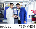 Engineer and technician discussing production process at factory 76646436