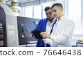 Engineer and technician discussing production process at factory 76646438