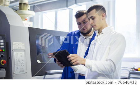 Engineer and technician discussing production process at factory Engineer and technician discussing production process at factory 76646438