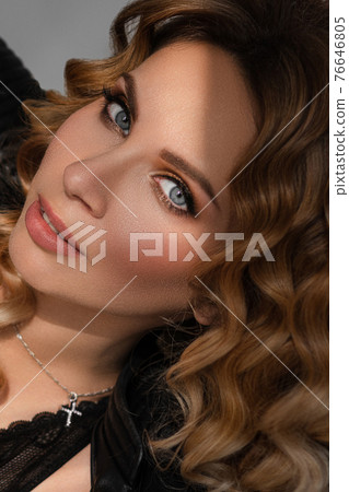 Gorgeous woman with rosebud in closeup holding a 76646805