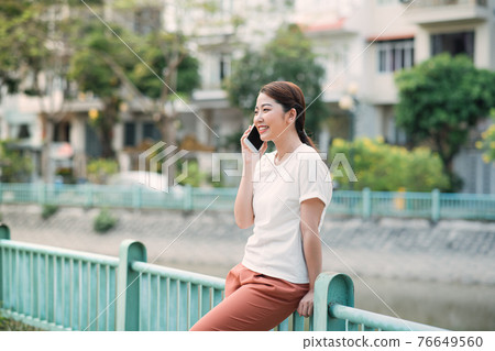 Young Beautiful Woman Talking On Mobile Phone Outdoor. Young Beautiful Woman Talking On Mobile Phone Outdoor. 76649560