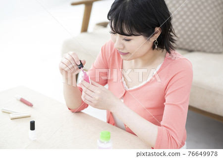 Young woman opening manicure lid in room Young woman opening manicure lid in room 76649978