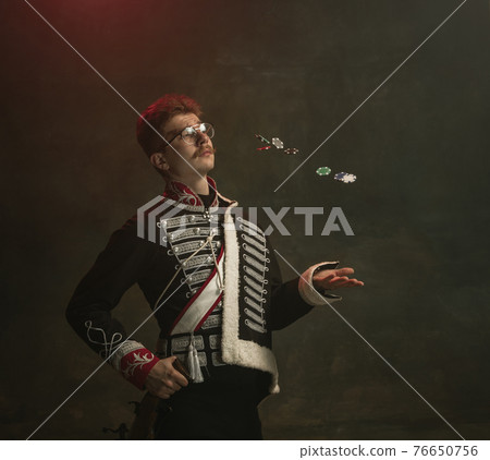 Young man in suit as royal person isolated on dark green background. Retro style, comparison of eras concept. Beautiful male model like historical character, monarch, old-fashioned. Young man in suit as royal person isolated on dark green background. Retro style, comparison of eras concept. Beautiful male model like historical character, monarch, old-fashioned. 76650756
