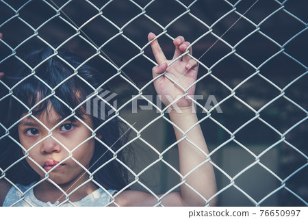 sad Asian girl child alone in cage was imprisoned make no freedom or lack of freedom 76650997