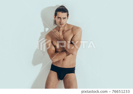 Muscle strong beautiful stripped male model in black underwear on white isolated font background with shadow Muscle strong beautiful stripped male model in black underwear on white isolated font background with shadow 76651233