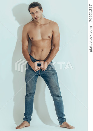 Muscle strong beautiful stripped male model in denim jeans on white isolated font background with shadow Muscle strong beautiful stripped male model in denim jeans on white isolated font background with shadow 76651237