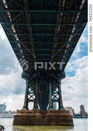 Iconic View Under Manhattan Bridge Against Cityscape of New York City Iconic View Under Manhattan Bridge Against Cityscape of New York City 76652204