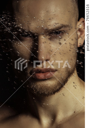 Handsome sport sexy stripped guy portrait in water drops on isolated black background 76652816