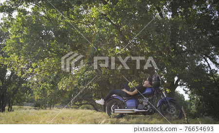 motorcyclist guy lying on a motorcycle. motorcyclist guy motorcyclist guy lying on a motorcycle. motorcyclist guy 76654693