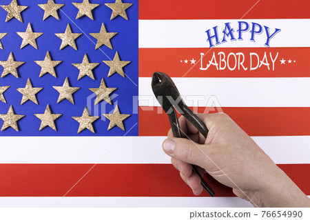 Happy Labor Day. Metal pliers in man's hand. Happy Labor Day. Metal pliers in man's hand. 76654990